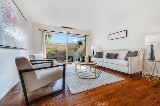 living room with wood-type flooring and a wall mounted AC