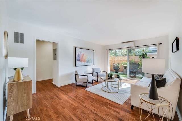 living room with wood-type flooring and a wall mounted air conditioner