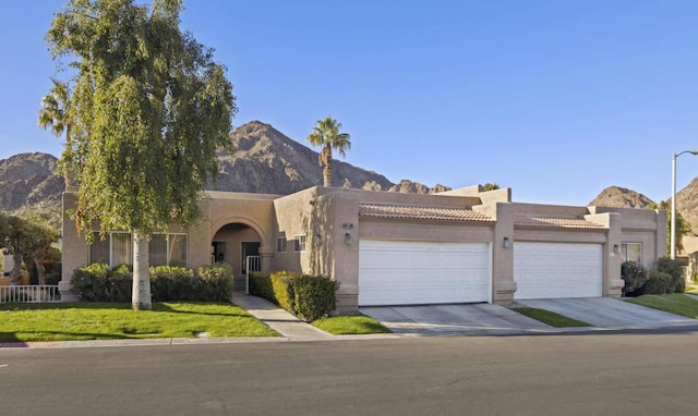 view of front of house featuring a front yard, a garage, and a mountain view