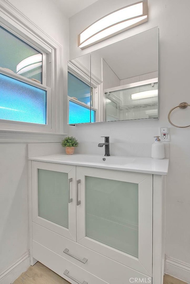 bathroom featuring a stall shower, vanity, and a healthy amount of sunlight