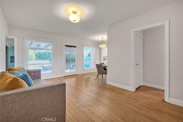 living area with baseboards and wood finished floors