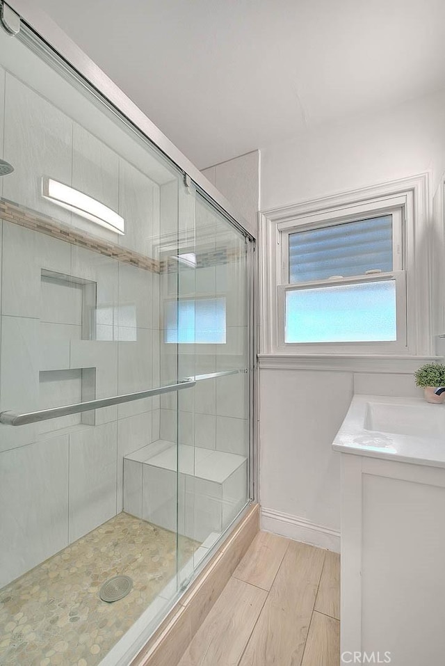 full bath with a stall shower, baseboards, and vanity