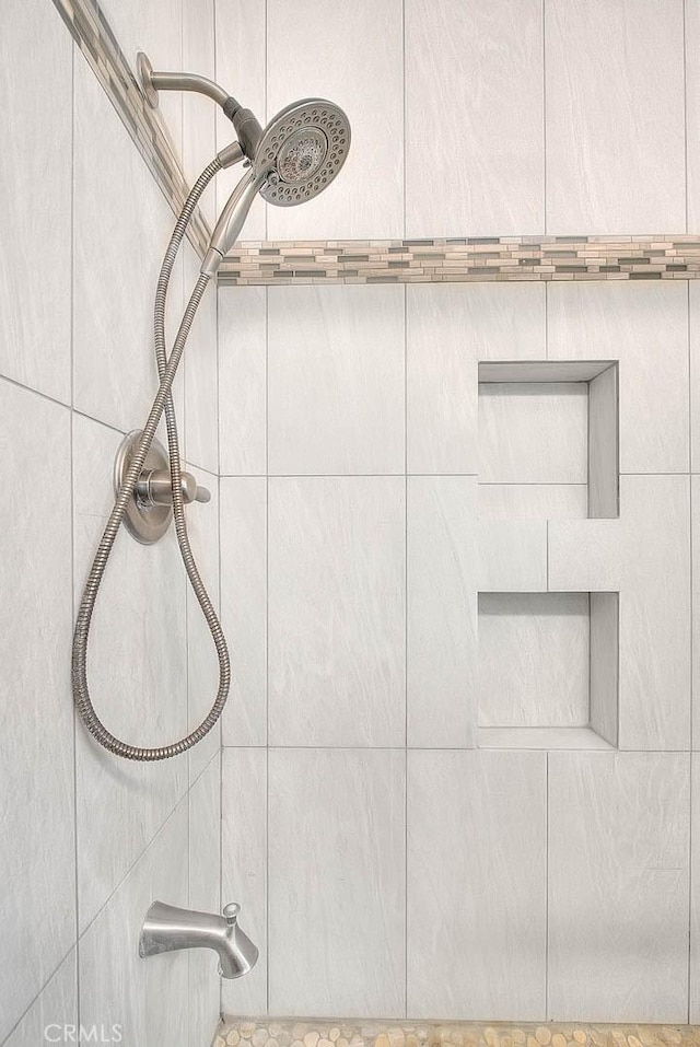 interior details featuring tiled shower