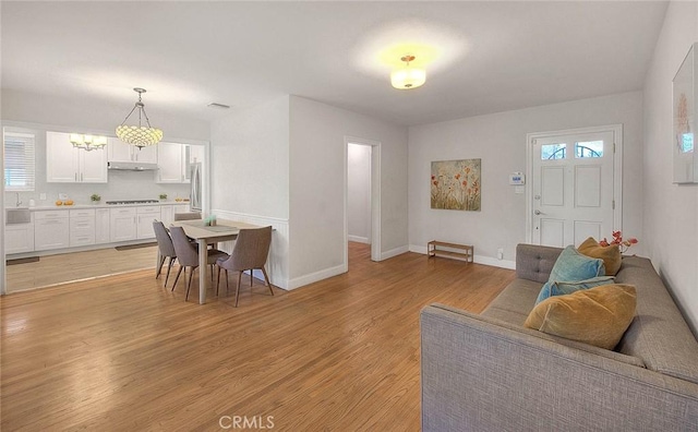 interior space with light wood-style floors, visible vents, and baseboards