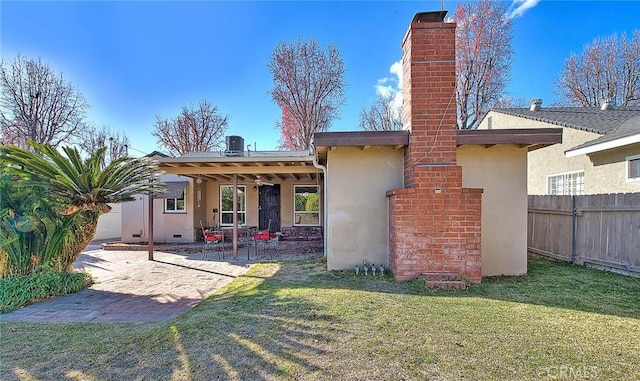 back of house with a lawn, fence, a patio, and stucco siding