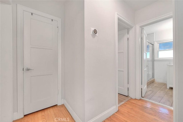 hallway featuring light wood-style floors and baseboards