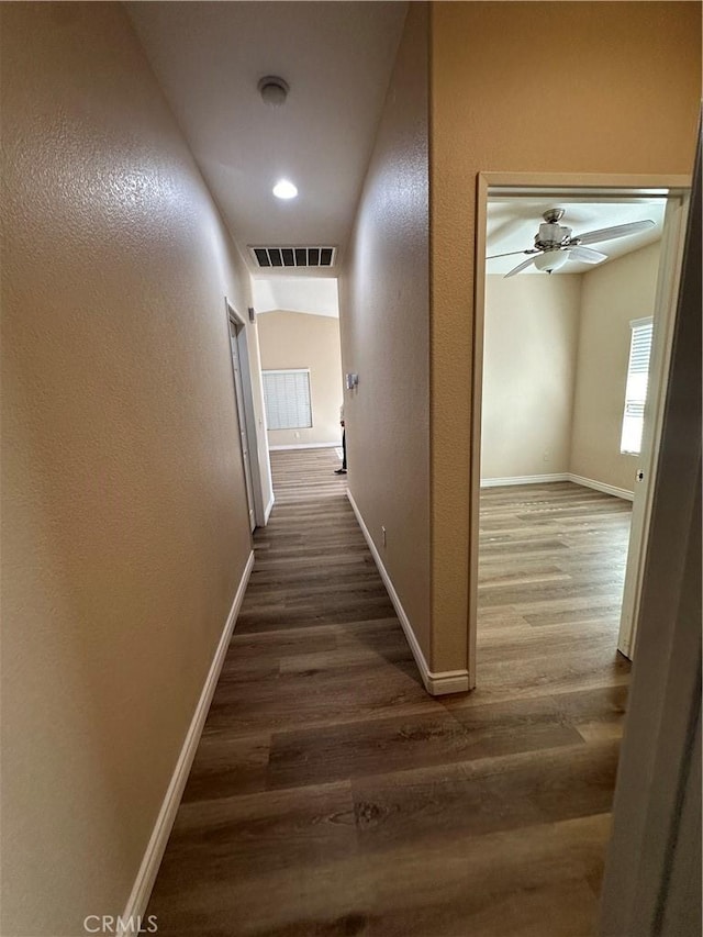 corridor featuring dark hardwood / wood-style flooring and vaulted ceiling