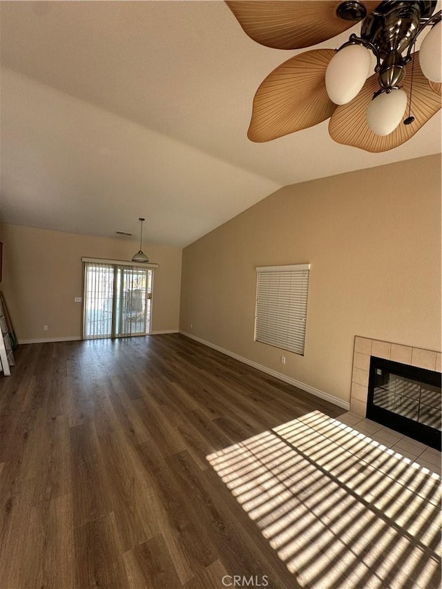 unfurnished living room featuring vaulted ceiling, ceiling fan, dark hardwood / wood-style flooring, and a fireplace