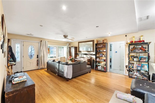 living room featuring ceiling fan and light hardwood / wood-style flooring