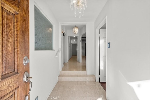 corridor with an inviting chandelier and light tile patterned floors