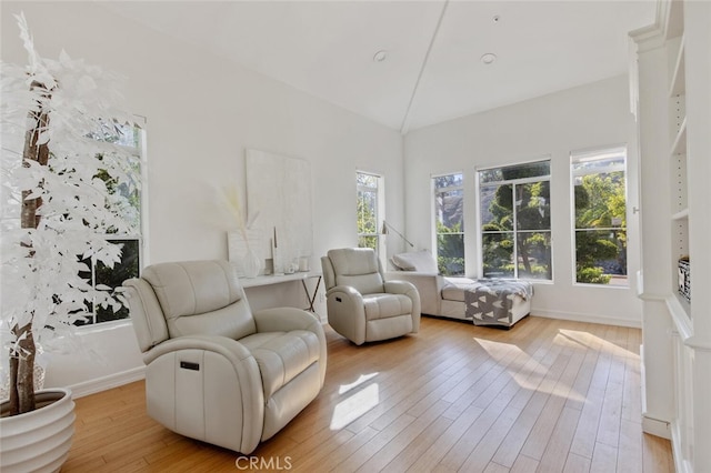 sitting room with vaulted ceiling and light hardwood / wood-style floors