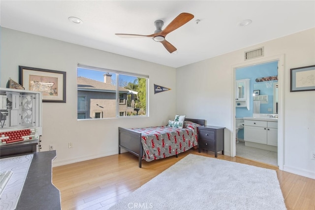 bedroom with ceiling fan, ensuite bathroom, and light hardwood / wood-style floors