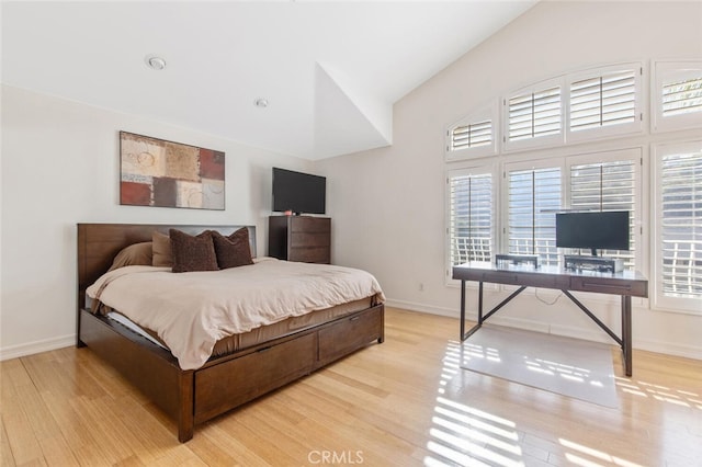 bedroom with vaulted ceiling and light wood-type flooring