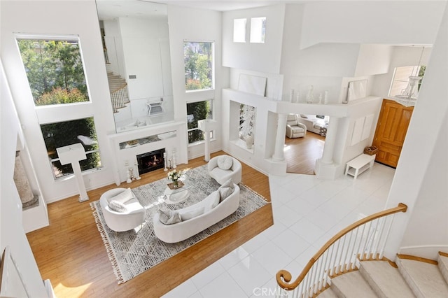 tiled living room featuring a fireplace and a high ceiling