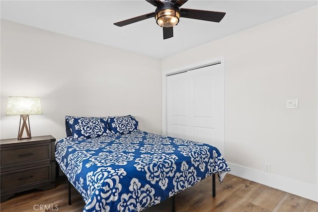 bedroom with ceiling fan, a closet, and hardwood / wood-style floors