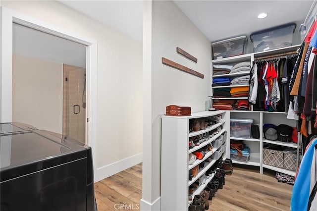 spacious closet featuring washing machine and dryer and hardwood / wood-style floors