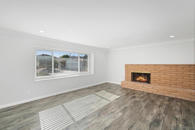 unfurnished living room with a brick fireplace, crown molding, and hardwood / wood-style floors