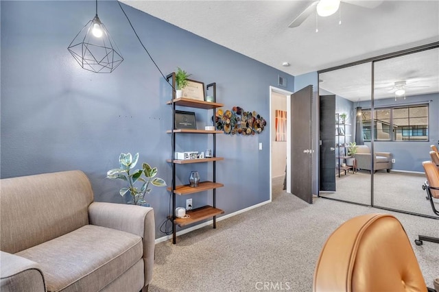 sitting room featuring carpet and ceiling fan