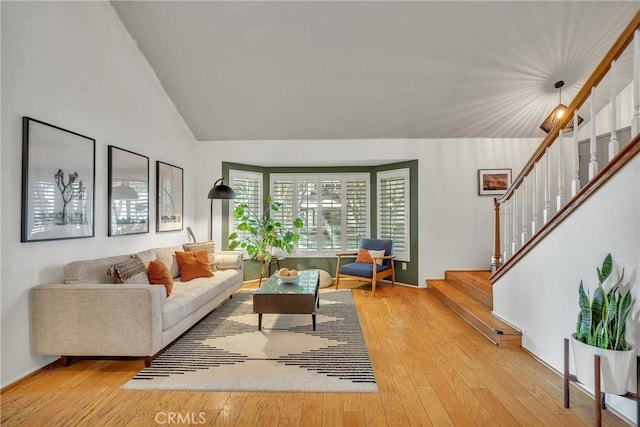 living room featuring lofted ceiling and hardwood / wood-style flooring