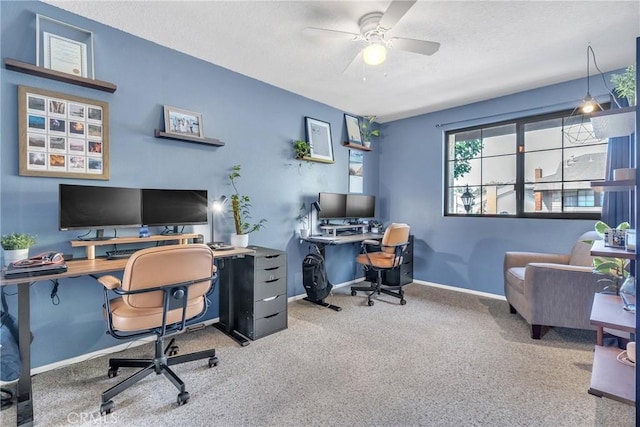 carpeted home office featuring ceiling fan