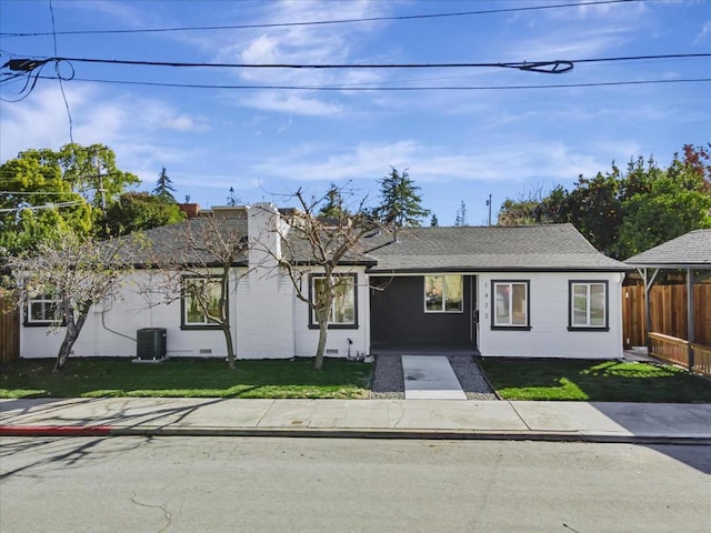 ranch-style house with central AC unit and a front yard