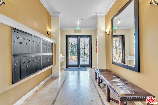 tiled entryway featuring crown molding and a mail area