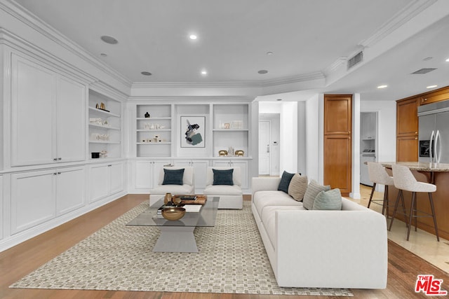 living room with light wood-type flooring and crown molding