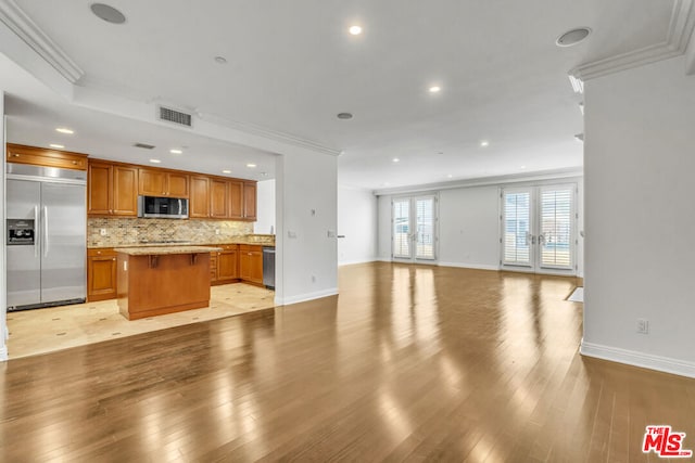 kitchen with a kitchen island, ornamental molding, stainless steel appliances, and a breakfast bar area