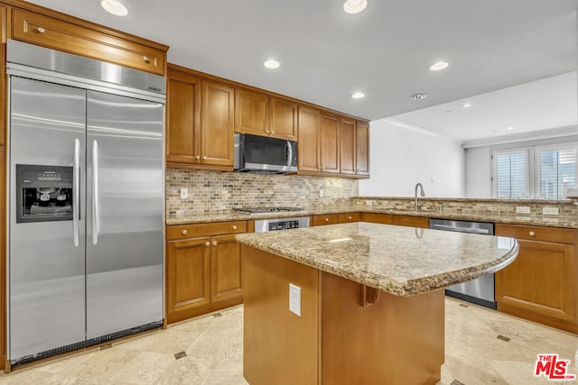 kitchen featuring backsplash, crown molding, sink, a kitchen island, and stainless steel appliances