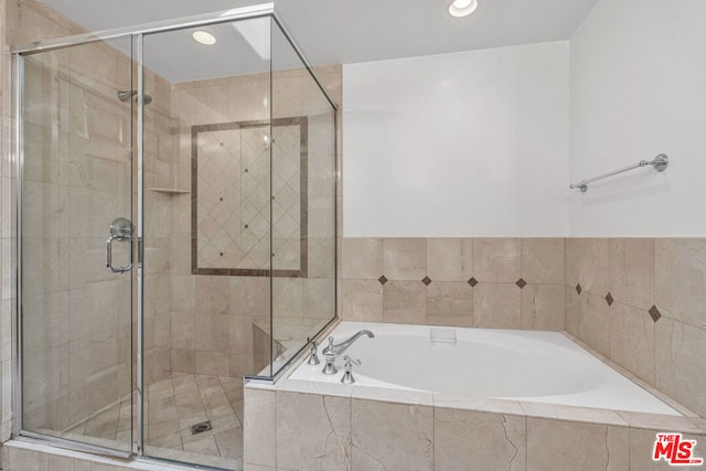 bathroom featuring shower with separate bathtub