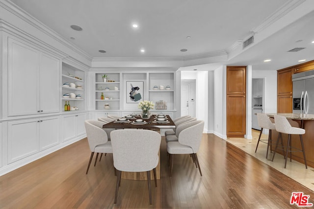 dining space featuring built in shelves, light hardwood / wood-style floors, and ornamental molding