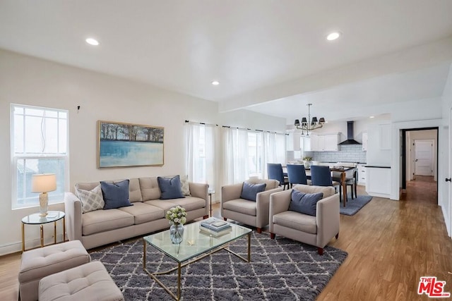 living room featuring hardwood / wood-style flooring, an inviting chandelier, and beamed ceiling