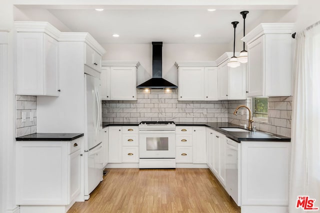 kitchen with decorative light fixtures, sink, white cabinets, white appliances, and wall chimney exhaust hood