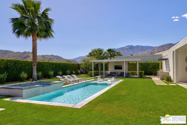 view of pool featuring ceiling fan, a mountain view, and a yard