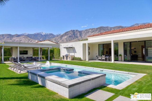 rear view of property with ceiling fan, an outdoor living space, a mountain view, and a patio