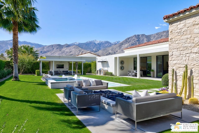 rear view of property featuring a mountain view, outdoor lounge area, a yard, and a patio area