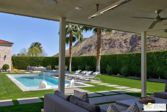 view of swimming pool featuring ceiling fan, a lawn, a patio, and an in ground hot tub