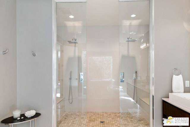 bathroom featuring a shower with shower door and vanity