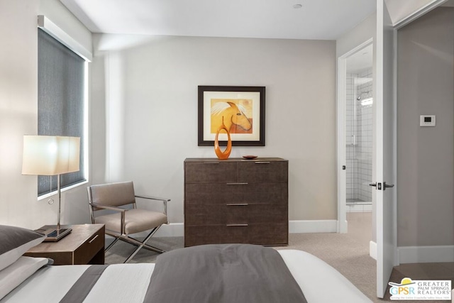 bedroom with ensuite bath, light colored carpet, and multiple windows