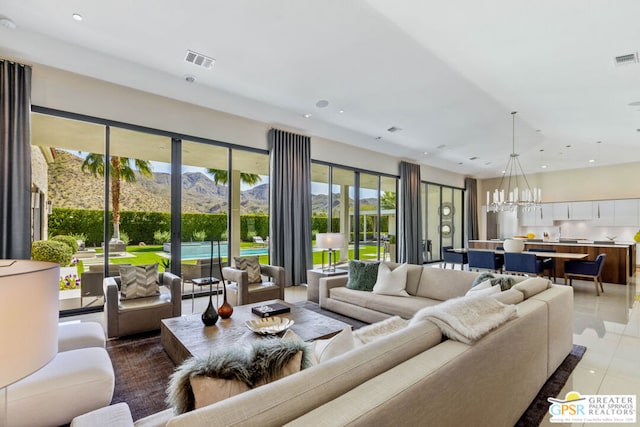 living room with an inviting chandelier, tile patterned floors, and a mountain view