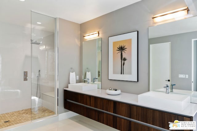 bathroom featuring tile patterned flooring, a tile shower, and vanity