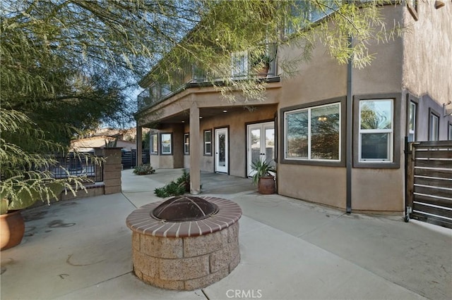 back of property with a patio and a fire pit