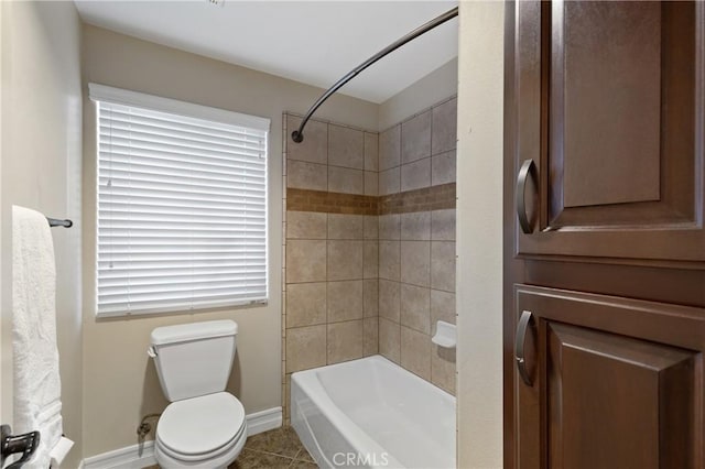 bathroom with toilet, tiled shower / bath combo, and tile patterned floors