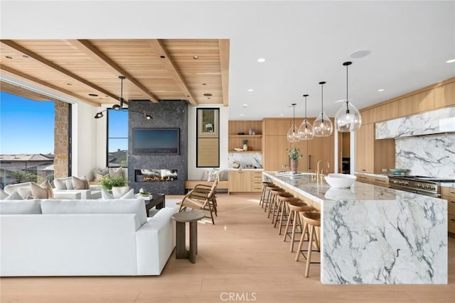 living room featuring wooden ceiling, light hardwood / wood-style floors, a fireplace, and beam ceiling