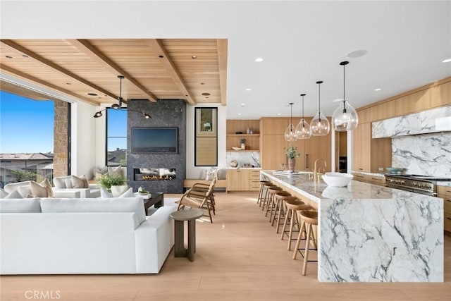 living area with recessed lighting, light wood-style floors, a large fireplace, wood ceiling, and beamed ceiling