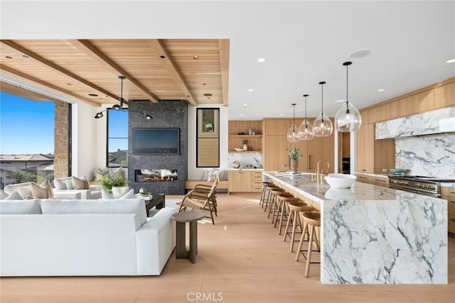 living room featuring wooden ceiling, light wood finished floors, a fireplace, and beam ceiling