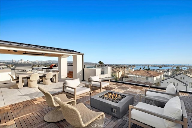 view of patio / terrace featuring a water view, grilling area, and an outdoor living space with a fire pit