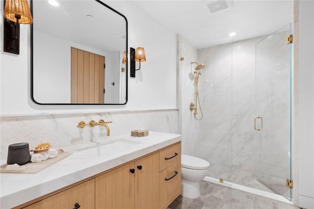 full bath with toilet, vanity, and a marble finish shower