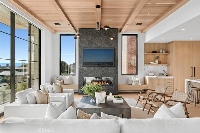 living room with a fireplace, wood finished floors, wood ceiling, beamed ceiling, and a wall of windows