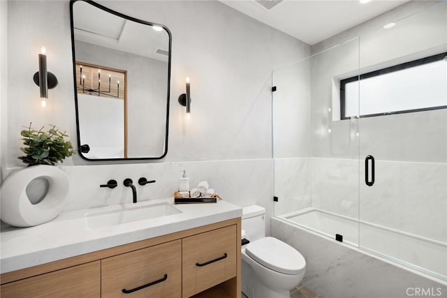 full bathroom with visible vents, shower / bath combination with glass door, vanity, and toilet